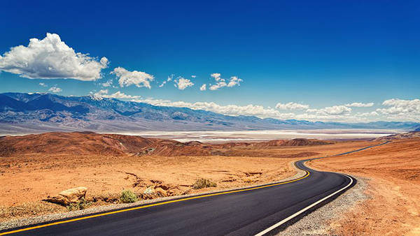 A lone road stretches into the desert.