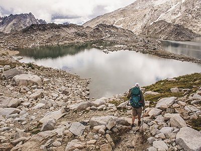 A Hiker looking at a spring located in the middle of a mountain.