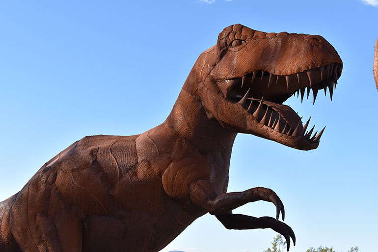 a model of a t-rex, made out of clay.