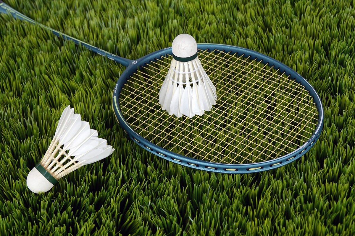 A Close-up of a badminton racket on a lawn of grass