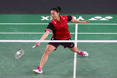 Badminton player Michelle Li hitting a badminton shuttlecock