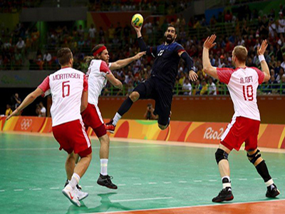 A Handball player jumps to make a play.