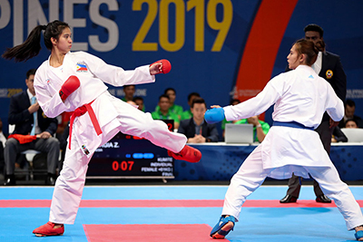 Two female karatekas face off in the ring