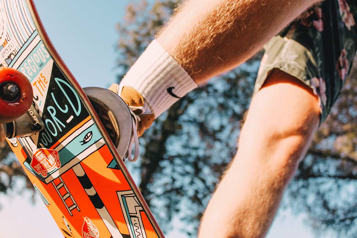 A Close-up of Andres Bester's legs while in the middle of a skateboard trick.