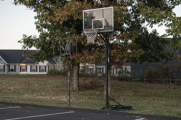 Two basketball hoops side-by-side, the left is more degraded than the right