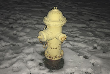 A Yellow hydrant blanketed in snow