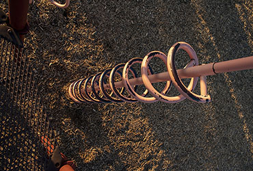 An angled shot of a spiral slide at a playground at dusk.